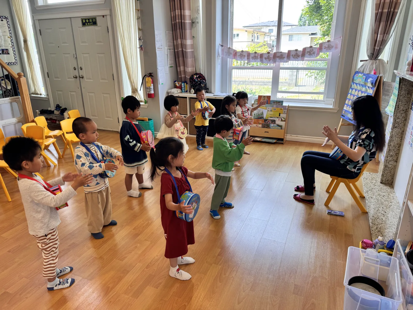 Children playing hand drums together during music time